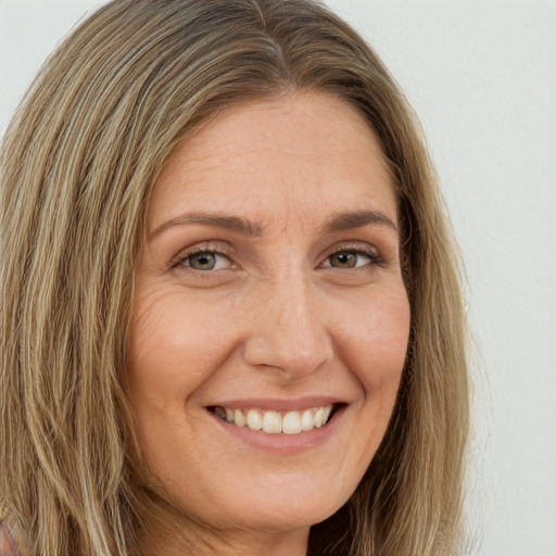 Joyful white adult female with long  brown hair and green eyes