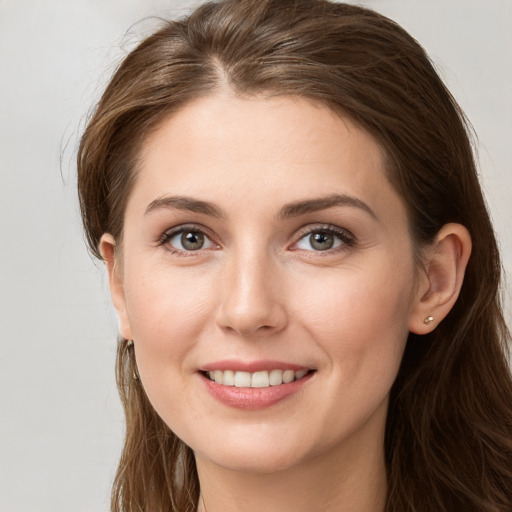 Joyful white young-adult female with long  brown hair and grey eyes