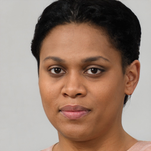 Joyful black young-adult female with short  black hair and brown eyes