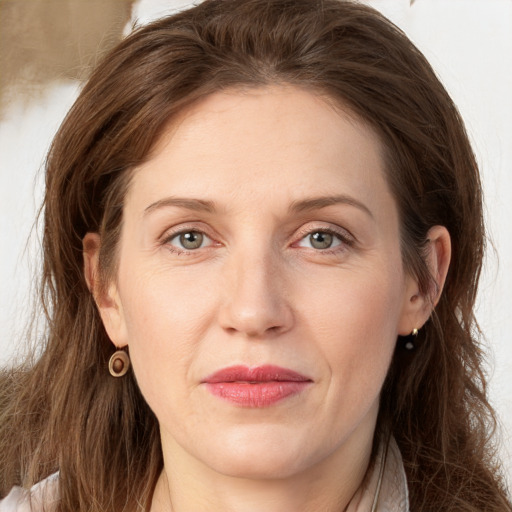 Joyful white adult female with long  brown hair and grey eyes