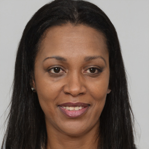 Joyful black adult female with long  brown hair and brown eyes