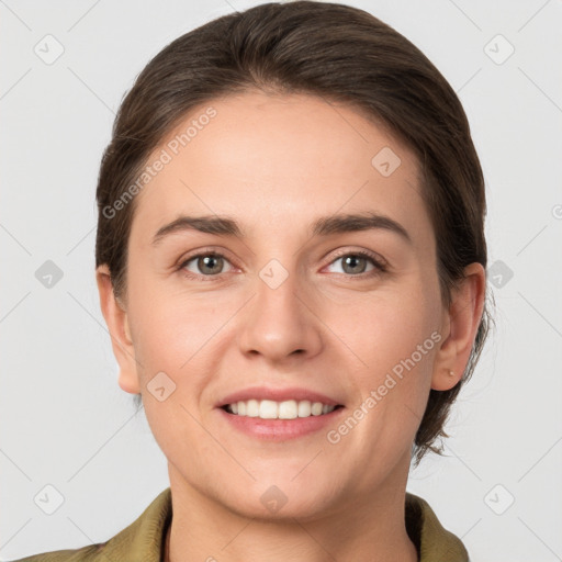 Joyful white young-adult female with medium  brown hair and grey eyes