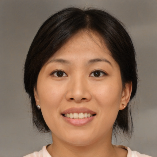 Joyful asian young-adult female with medium  brown hair and brown eyes