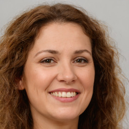 Joyful white young-adult female with long  brown hair and green eyes