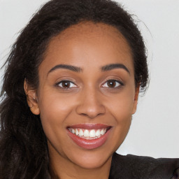 Joyful black young-adult female with long  brown hair and brown eyes