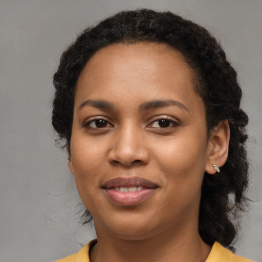 Joyful black young-adult female with medium  brown hair and brown eyes