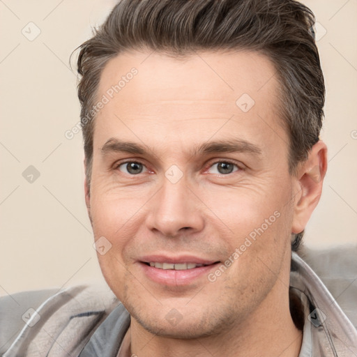 Joyful white adult male with short  brown hair and brown eyes