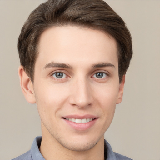 Joyful white young-adult male with short  brown hair and grey eyes