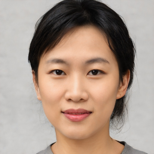 Joyful asian young-adult female with medium  black hair and brown eyes