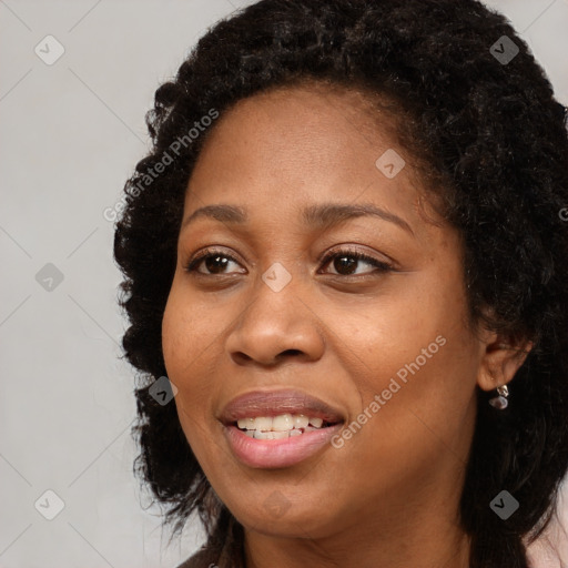 Joyful black adult female with long  brown hair and brown eyes