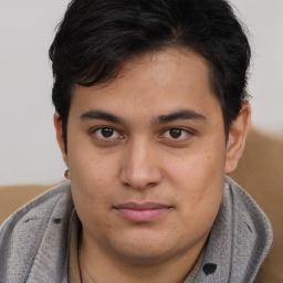 Joyful latino young-adult male with short  brown hair and brown eyes