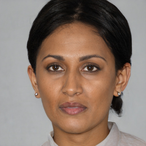 Joyful latino adult female with short  black hair and brown eyes