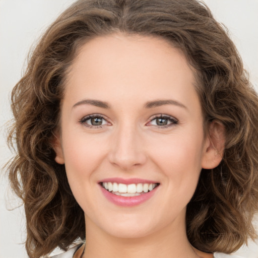 Joyful white young-adult female with long  brown hair and green eyes