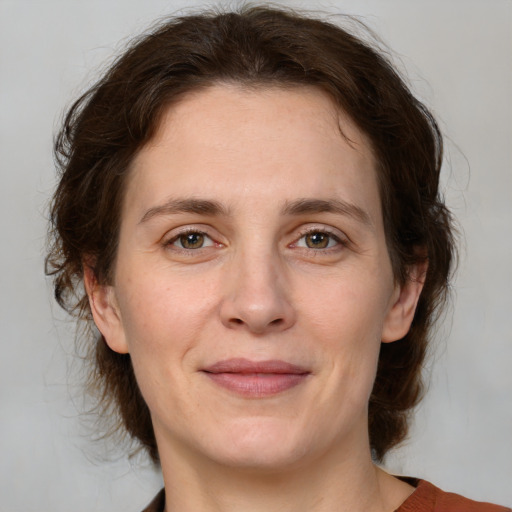 Joyful white adult female with medium  brown hair and green eyes