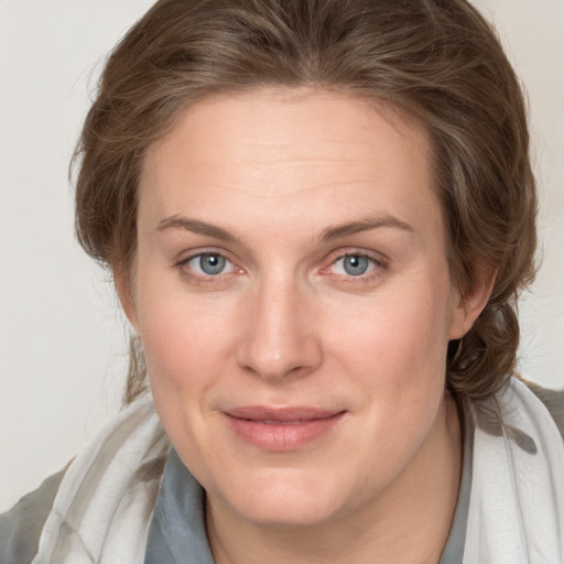 Joyful white adult female with medium  brown hair and grey eyes