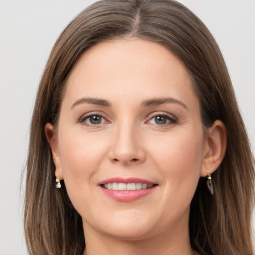 Joyful white young-adult female with long  brown hair and grey eyes