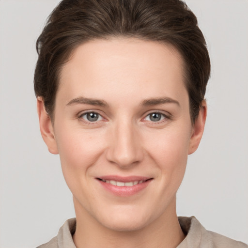 Joyful white young-adult female with short  brown hair and grey eyes