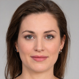 Joyful white young-adult female with medium  brown hair and green eyes