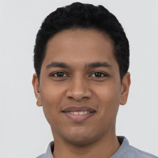 Joyful latino young-adult male with short  black hair and brown eyes