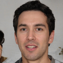 Joyful white young-adult male with short  black hair and brown eyes