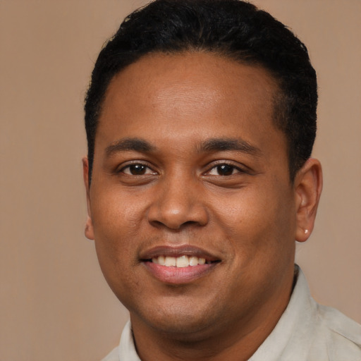 Joyful black young-adult male with short  black hair and brown eyes