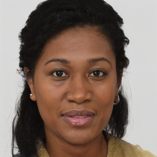 Joyful black adult female with long  brown hair and brown eyes