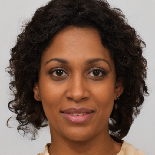 Joyful black adult female with medium  brown hair and brown eyes