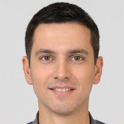 Joyful white young-adult male with short  brown hair and brown eyes