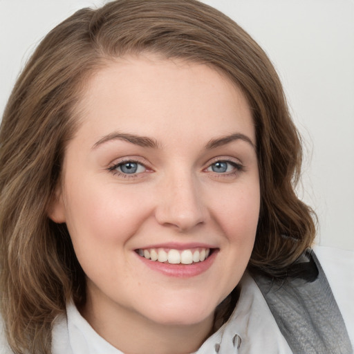 Joyful white young-adult female with medium  brown hair and blue eyes