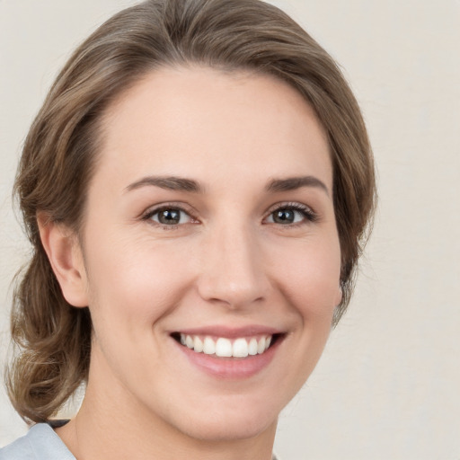 Joyful white young-adult female with medium  brown hair and green eyes