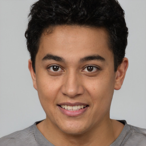 Joyful latino young-adult male with short  brown hair and brown eyes