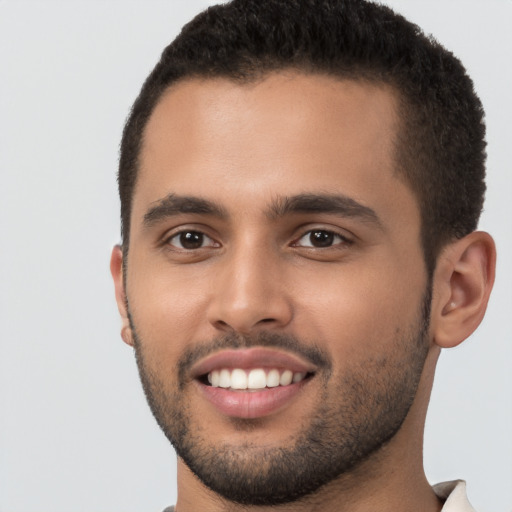 Joyful black young-adult male with short  brown hair and brown eyes