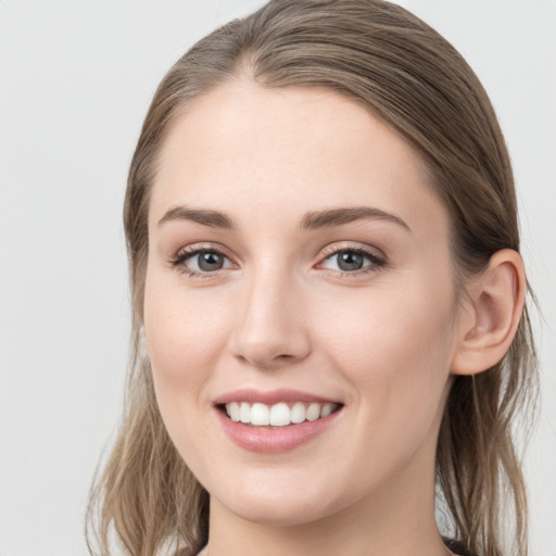 Joyful white young-adult female with long  brown hair and grey eyes