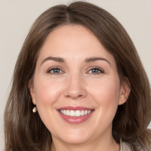 Joyful white adult female with medium  brown hair and grey eyes