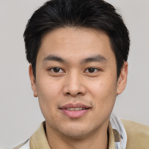 Joyful asian young-adult male with short  brown hair and brown eyes