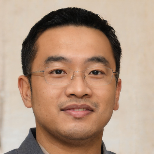 Joyful asian young-adult male with short  black hair and brown eyes