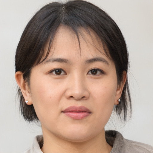 Joyful asian young-adult female with medium  brown hair and brown eyes