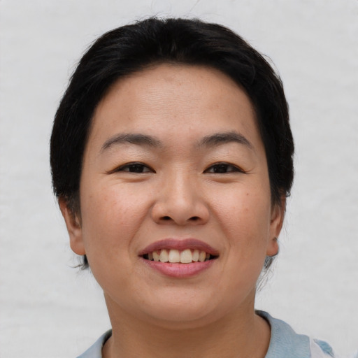 Joyful asian young-adult female with short  brown hair and brown eyes