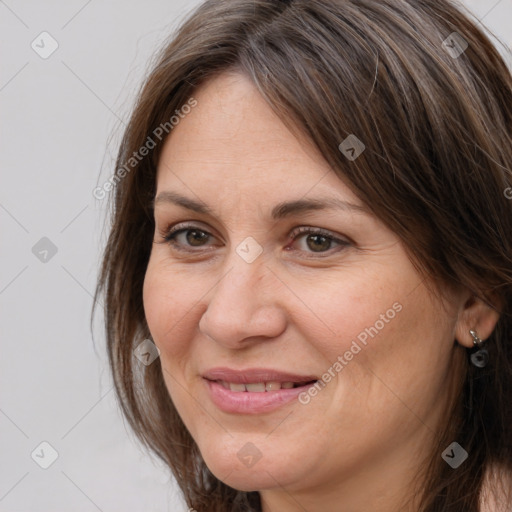 Joyful white adult female with long  brown hair and brown eyes