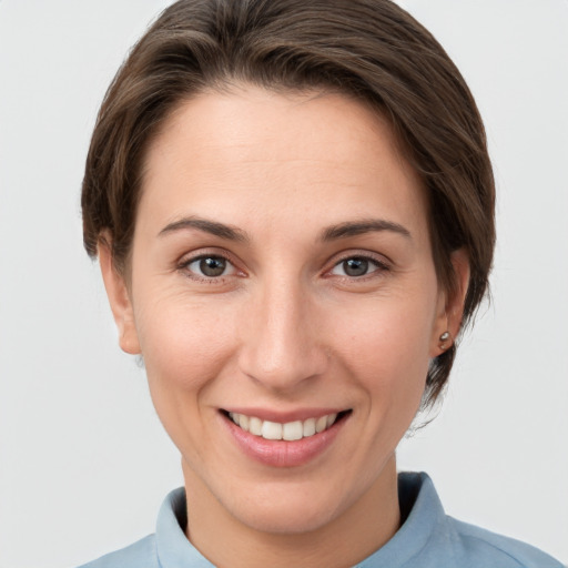 Joyful white young-adult female with short  brown hair and grey eyes