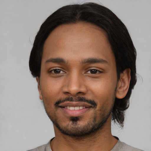 Joyful black young-adult male with short  black hair and brown eyes