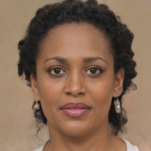 Joyful black adult female with long  brown hair and brown eyes