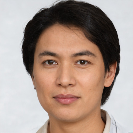 Joyful asian young-adult male with short  brown hair and brown eyes
