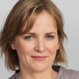 Joyful white adult female with medium  brown hair and grey eyes