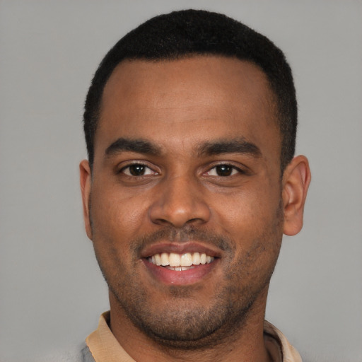 Joyful black young-adult male with short  black hair and brown eyes