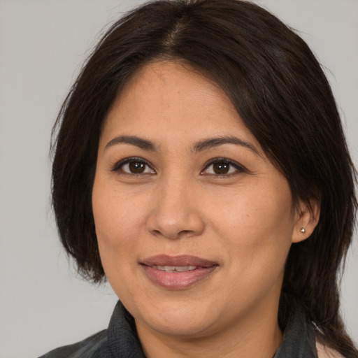 Joyful asian adult female with medium  brown hair and brown eyes