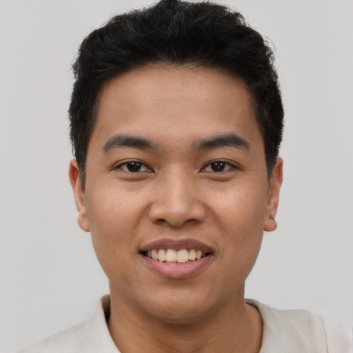 Joyful latino young-adult male with short  brown hair and brown eyes