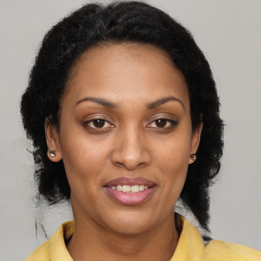 Joyful black young-adult female with medium  brown hair and brown eyes