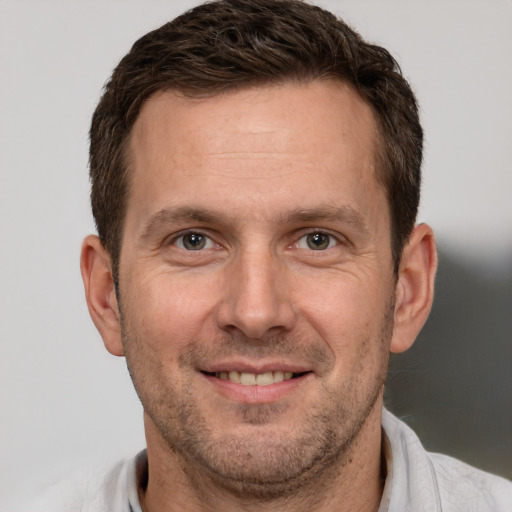 Joyful white adult male with short  brown hair and brown eyes