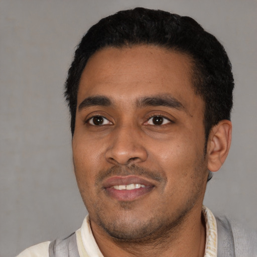 Joyful latino young-adult male with short  black hair and brown eyes